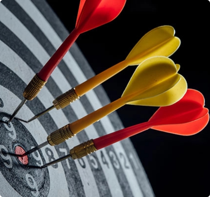 Freccette colorate conficcate al centro di un bersaglio, simbolo di precisione e successo.